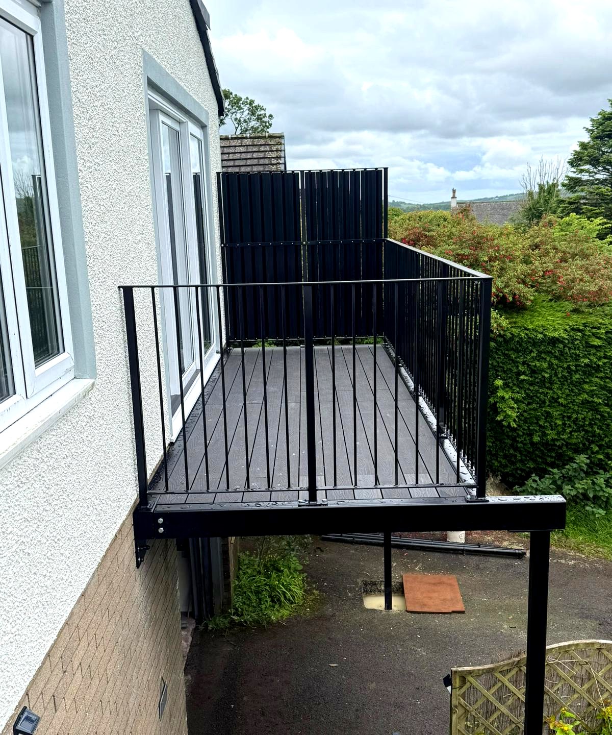 Black metal balustrade and black composite decking on a walkout balcony, Crummock, Cumbria